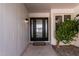 The home's entrance featuring a modern black front door with sidelights and a welcoming covered porch at 19817 N Ponderosa Cir, Sun City, AZ 85373