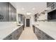 Kitchen featuring stainless steel appliances, gray cabinets, and quartz countertops at 19817 N Ponderosa Cir, Sun City, AZ 85373