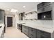 Modern kitchen with stainless appliances, gray cabinets, and quartz countertops at 19817 N Ponderosa Cir, Sun City, AZ 85373