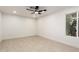 Bright, freshly painted living room with tile floors, ceiling fan, and window view of greenery at 19817 N Ponderosa Cir, Sun City, AZ 85373