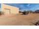 View of the garage exterior, showcasing the garage door, adjacent trailer and surrounding desert landscape at 205 E Irvine Rd, Phoenix, AZ 85086