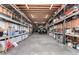 Spacious garage interior with ample storage shelves, concrete floors, and wooden ceiling supports, boat stored within at 205 E Irvine Rd, Phoenix, AZ 85086