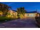 Well-lit exterior of a home at night, showcasing the driveway, landscaping, and architectural details at 2125 W Berridge Ln, Phoenix, AZ 85015