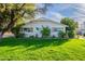 Charming single-story home with a well-maintained lawn, mature trees, and wooden shutters at 2125 W Berridge Ln, Phoenix, AZ 85015