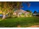 Charming front yard of a home, featuring a mature tree, lush lawn, and manicured landscaping at 2125 W Berridge Ln, Phoenix, AZ 85015