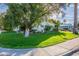 Charming home exterior with a lush green lawn, mature tree, and well-maintained landscaping at 2125 W Berridge Ln, Phoenix, AZ 85015