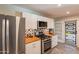 Modern kitchen featuring stainless steel appliances, white cabinets, wood countertops, and an artistic backsplash at 2125 W Berridge Ln, Phoenix, AZ 85015