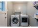 Efficient laundry room equipped with appliances and storage shelves, designed for seamless chores at 2125 W Berridge Ln, Phoenix, AZ 85015