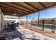 Covered patio with a dining set overlooks the backyard pool, offering a serene outdoor living space at 2129 N Apollo Ct, Chandler, AZ 85224