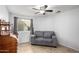 Well-lit living room with a comfortable gray loveseat, window, and wooden writing desk area at 2129 N Apollo Ct, Chandler, AZ 85224