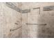 Walk-in shower featuring stylish tile work and a shower head, along with safety bars at 2129 N Apollo Ct, Chandler, AZ 85224