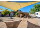 Open backyard with a canvas shade, rustic patio, desert landscaping, and detached camper trailer at 2217 N 37Th Pl, Phoenix, AZ 85008