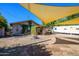 Open backyard beneath a canvas shade features a desert landscape, rustic patio, and detached camper at 2217 N 37Th Pl, Phoenix, AZ 85008