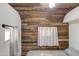 Cozy bedroom featuring wood accent wall, small window and white walls at 2217 N 37Th Pl, Phoenix, AZ 85008