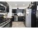 Modern kitchen featuring sleek black cabinets, stainless steel appliances, and herringbone wood floors at 2217 N 37Th Pl, Phoenix, AZ 85008