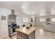 Open concept kitchen with stainless steel appliances, black cabinets, and tile flooring at 2217 N 37Th Pl, Phoenix, AZ 85008