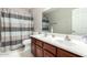 Bathroom with a double sink vanity, a toilet, and a shower curtain with gray, white, and blue stripes at 23510 N 25Th St, Phoenix, AZ 85024