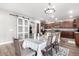 Dining area features modern chandelier, wood floors, and sliding door access to backyard at 23510 N 25Th St, Phoenix, AZ 85024