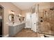 An elegant bathroom features double sinks with granite countertops and a glass-enclosed shower with modern finishes at 24024 N 74Th St, Scottsdale, AZ 85255