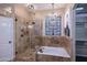 Luxurious bathroom featuring a glass-enclosed shower, soaking tub, and elegant chandelier at 24024 N 74Th St, Scottsdale, AZ 85255