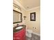 Charming powder room with red vanity, granite countertop, and decorative mirror at 24024 N 74Th St, Scottsdale, AZ 85255