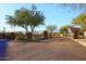 Gated entrance to a desert community with mature trees and desert vegetation at 24024 N 74Th St, Scottsdale, AZ 85255