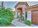 Inviting entrance with stone pathway and an arched doorway with decorative potted plants at 24024 N 74Th St, Scottsdale, AZ 85255