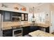 Modern kitchen with black cabinets, granite countertops, stainless steel appliances, and a window above the sink at 24024 N 74Th St, Scottsdale, AZ 85255