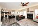 Open concept living room with fireplace, ceiling fan, hardwood floors, and access to the kitchen at 24024 N 74Th St, Scottsdale, AZ 85255