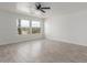 Bright bedroom featuring sleek flooring, a ceiling fan and large view windows at 28214 N 223Rd Ln, Wittmann, AZ 85361