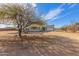 Attractive gray home featuring desert landscaping, two-car garage and beautiful blue sky at 28214 N 223Rd Ln, Wittmann, AZ 85361