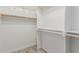 Spacious walk-in closet with ample shelving and wooden rods for organized storage at 28214 N 223Rd Ln, Wittmann, AZ 85361