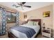 Inviting bedroom featuring a comfortable queen bed, ceiling fan, and serene decor for relaxation at 29247 N Bauxite Ln, San Tan Valley, AZ 85143