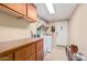 Bright laundry room featuring tile floor, storage cabinets, washer and dryer, and a white door at 29247 N Bauxite Ln, San Tan Valley, AZ 85143