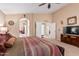 Bright main bedroom showcasing a ceiling fan, plush bedding, and an open layout to the ensuite bathroom at 29247 N Bauxite Ln, San Tan Valley, AZ 85143