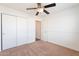 Bedroom with tan carpet, ceiling fan, and closet with slider doors at 3043 W Melinda Ln, Phoenix, AZ 85027