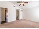 Inviting bedroom featuring carpet floors, neutral walls, ceiling fan and barn door to the ensuite bathroom at 3043 W Melinda Ln, Phoenix, AZ 85027