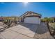 Single-story home featuring a two-car garage, low-maintenance landscaping, and a well-maintained driveway under a clear blue sky at 3043 W Melinda Ln, Phoenix, AZ 85027