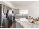 Modern kitchen with stainless steel appliances, speckled granite countertops, gray cabinets, and a tiled floor at 3043 W Melinda Ln, Phoenix, AZ 85027