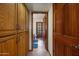 Hallway with wood cabinets and view of a full bathroom with a shower, toilet, and a sink with marble countertop at 3160 E Fox St, Mesa, AZ 85213