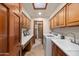 Well-equipped laundry room with cabinets, countertop space, laundry sink and modern appliances for convenience at 3160 E Fox St, Mesa, AZ 85213