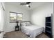 Bedroom featuring a window, ceiling fan, dark bookshelf, side table, and a comfortable bed at 3233 N 137Th Dr, Avondale, AZ 85392