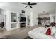 Bright living room with a fireplace, built-in shelves, and an open floor plan leading to the kitchen at 3233 N 137Th Dr, Avondale, AZ 85392