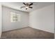 A carpeted bedroom featuring a ceiling fan, and a window offering natural light at 3235 E Virgil Dr, Gilbert, AZ 85298