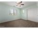 A cozy bedroom featuring a ceiling fan, carpet, and a window offering natural light at 3235 E Virgil Dr, Gilbert, AZ 85298