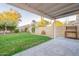 A covered patio extends to a backyard featuring a small patch of grass and a privacy wall at 3522 E Edna Ave, Phoenix, AZ 85032