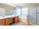 Well-lit bathroom with double vanity, bathtub, and separate glass-enclosed shower at 3522 E Edna Ave, Phoenix, AZ 85032