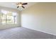 Bright bedroom featuring carpet, a ceiling fan, and a large window with a backyard view at 3522 E Edna Ave, Phoenix, AZ 85032