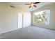 Bedroom featuring carpet, a ceiling fan, and a window offering backyard views at 3522 E Edna Ave, Phoenix, AZ 85032