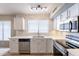 Bright kitchen featuring stainless steel appliances, tile backsplash and white cabinetry at 3522 E Edna Ave, Phoenix, AZ 85032